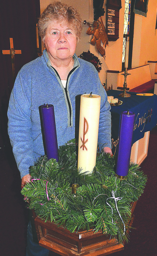 Rev. Liz Wilson, pastor of Immanuel Congregational United Church of Christ, stands with the three remaining Advent candles in the sanctuary. Photo by C.J. Carnacchio.