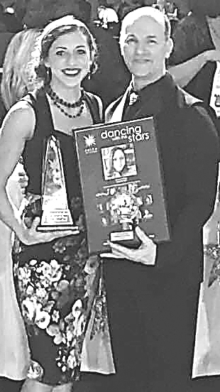 Oxford firefighter Amanda McBride (left) and her partner, Jim Everley, pose with their hardware at the end of the Dancing with the Stars fund-raiser for Faith in Action of Oakland County. Photo provided.