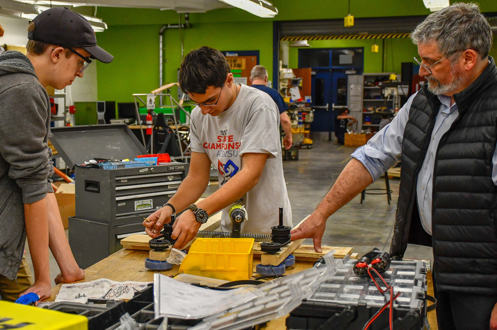 OHS students Alex Lundy and Brandon Hiscox, along with Mentor Andre LaRoche, help build the TORC 2137 robot. Photo provided.