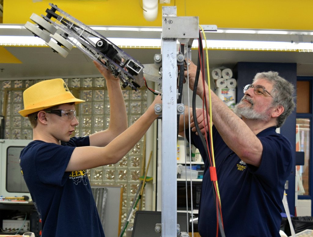 Sophomore Jason Grabowski and Mentor Andre LaRoche work on the TORC 2137 robot. Photo by Elise Shire.