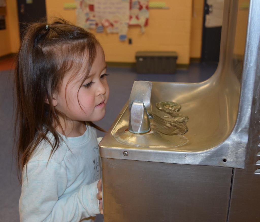 Alia Elsholz, a kindergartner at Clear Lake Elementary and member of the school's Green Team, takes a sip from one of the school's existing drinking fountains. Photo by Elise Shire.