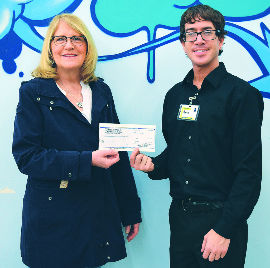 FISH Vice President Julie Howald (left) receives a $587 donation check from Adam Calimeri, assistant manager of the Goodwill store in Oxford. Photo by Elise Shire.