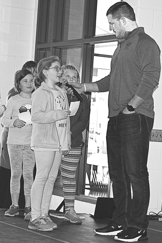 Cailyn Eller, an Oxford Elementary student, asks Line a question about reading. Photo by Elise Shire.