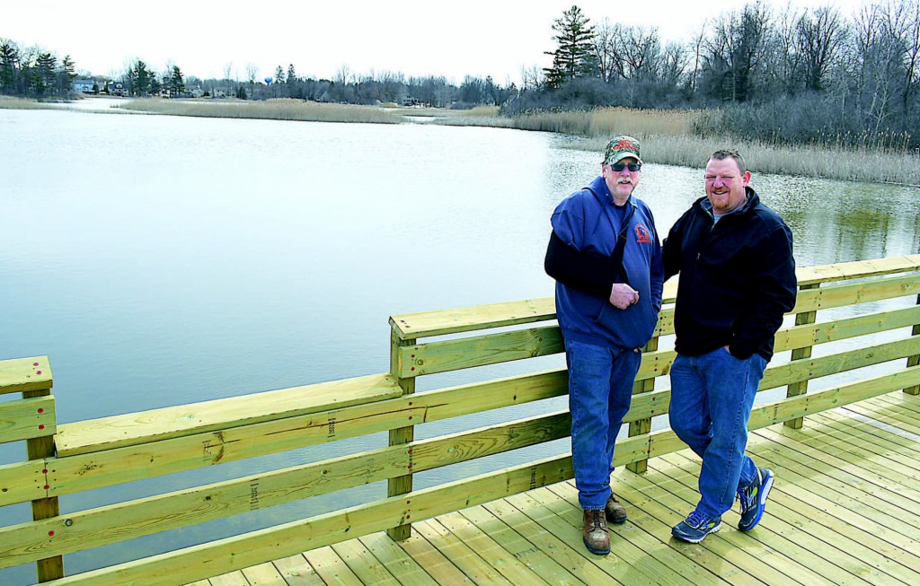 Oxford Twp. Parks/Rec. Director Ron Davis (right) and Park Superintendent Jeff Kinasz stand on the new observation/fishing pier at Powell Lake. To their left is one of the lower railings created to give people in wheelchairs the opportunity to fish. Photos by C.J. Carnacchio.