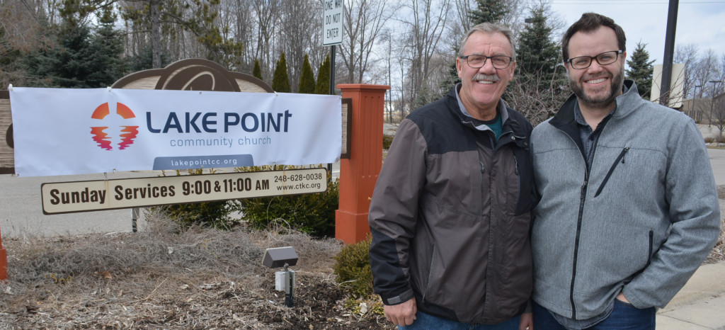 Senior Pastor Bob Holt (left) and his son, Executive Pastor Jesse Holt, stand beside the temporary sign for LakePoint Community Church. Photo by C.J. Carnacchio.