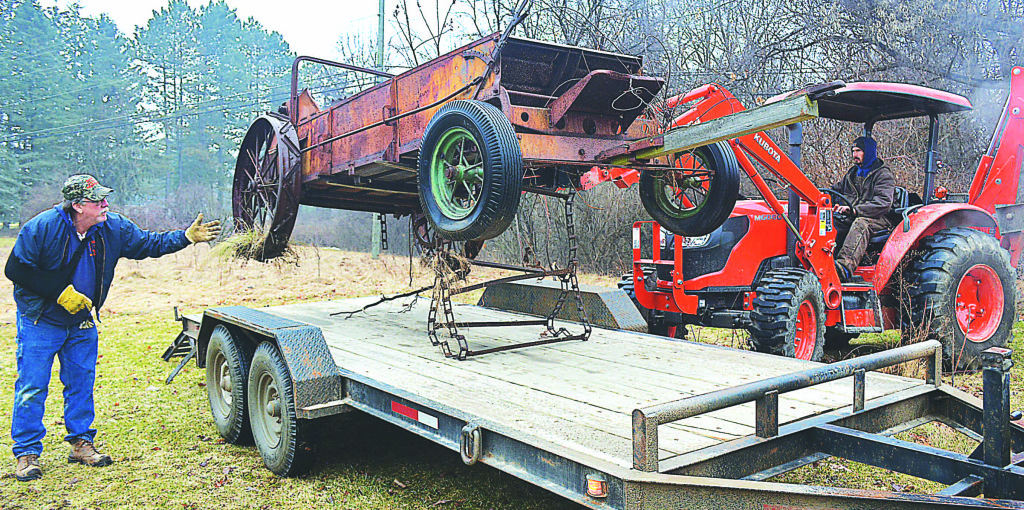 Jeff Kinasz, park superintendent for the Oxford Township Parks and Recreation Department, guides the antique manure spreader belonging to former Leader Publisher James A. Sherman, Sr. onto a trailer. Photo by C.J. Carnacchio.