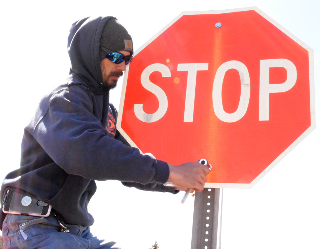 Parks/rec. employee Tom Ouelette installs a new stop sign in Seymour Lake Twp. Park. Photo by C.J. Carnacchio.
