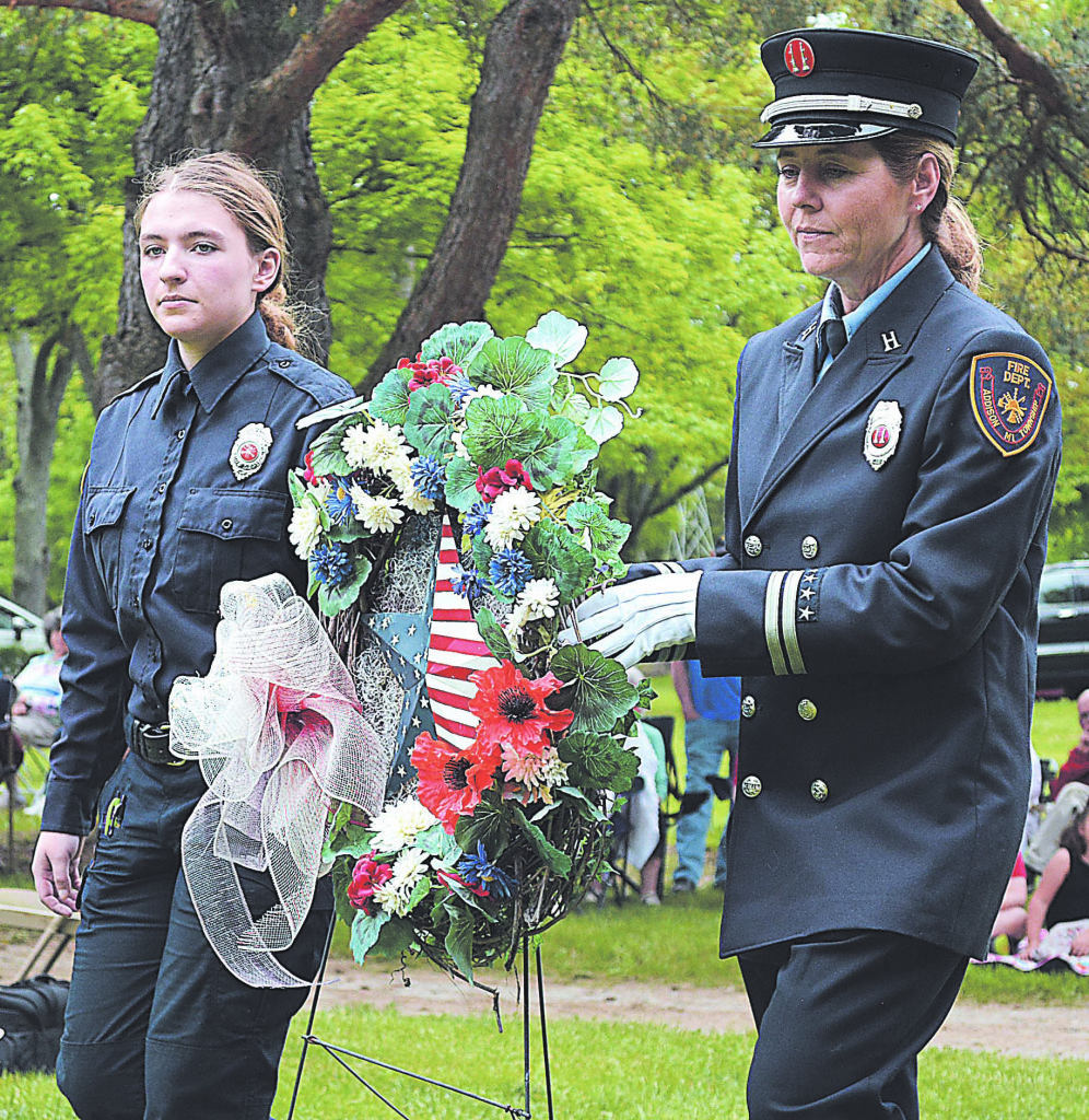 Addison Fire Captain Michelle Mead (right) and Firefighter Mackenzie Prey place a memorial wreath together. Photo by C.J. Carnacchio.