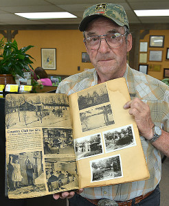 Jim Parkhurst, curator of the extensive military museum inside Oxford American Legion Post 108, holds a scrapbook containing newspaper clippings and photographs chronicling the activities of the Blue Star Mothers of America, Inc. Photo by C.J. Carnacchio.