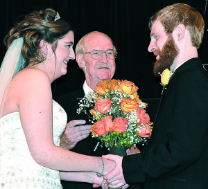 Retired Pastor Bob Service (center) officiated his 1,000th wedding ceremony Saturday at Oakwood Wedding Chapel in Oxford Township. He married Kaitlin Ormerod (left) and Lucas Conley. Photo by C.J. Carnacchio.