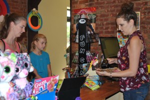 Allison Moore, a cashier at Funky Monkey Toys in downtown Oxford, assists a customer. Photo by Shelby Tankersley.