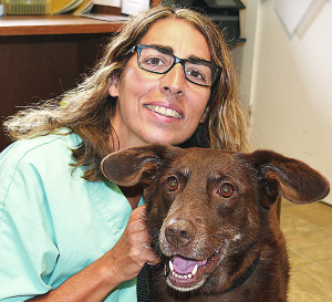 Dr. Elena Osborne, owner of Veterinary Home Care, poses with Marci, a Labrador Retriever mix available for adoption from the K9 Stray Rescue League. Photo by C.J. Carnacchio.