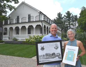 Ken and Diane Matheis pose outside their historic Addison Township farmhouse. It was built around 1860 by Henry and Margaretta Purse. Ken is holding a drawing of the Purses and the house. Diane is holding one of five awards the home received from Detroit Home Magazine in 2016. Photo by C.J. Carnacchio.