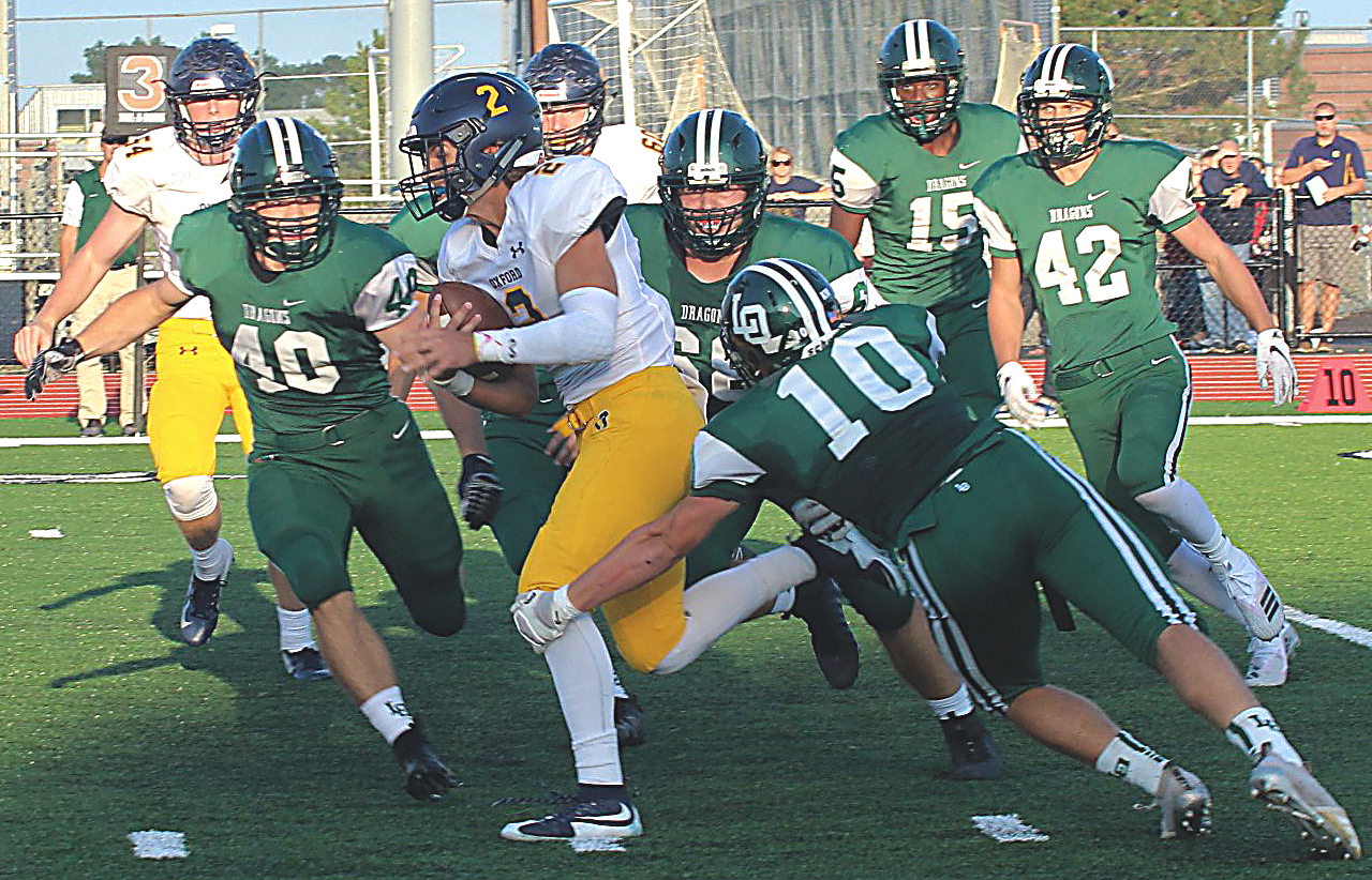 Surrounded by Dragon defenders, Oxford QB Drew Carpenter runs the ball. Photo by Joe St. Henry.