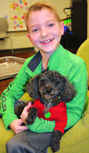 Gavin Lawrey, a fifth-grader at OES, holds  Hershey, his service dog. Photo by C.J. Carnacchio.