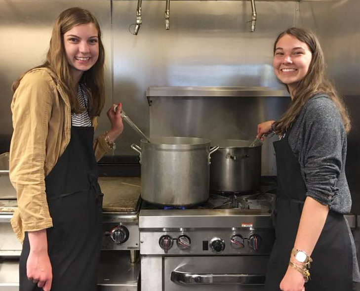 The Blair sisters cook food while volunteering at Grace Centers of Hope in Pontiac with the I’m 3rd student volunteer group. Photo provided. 