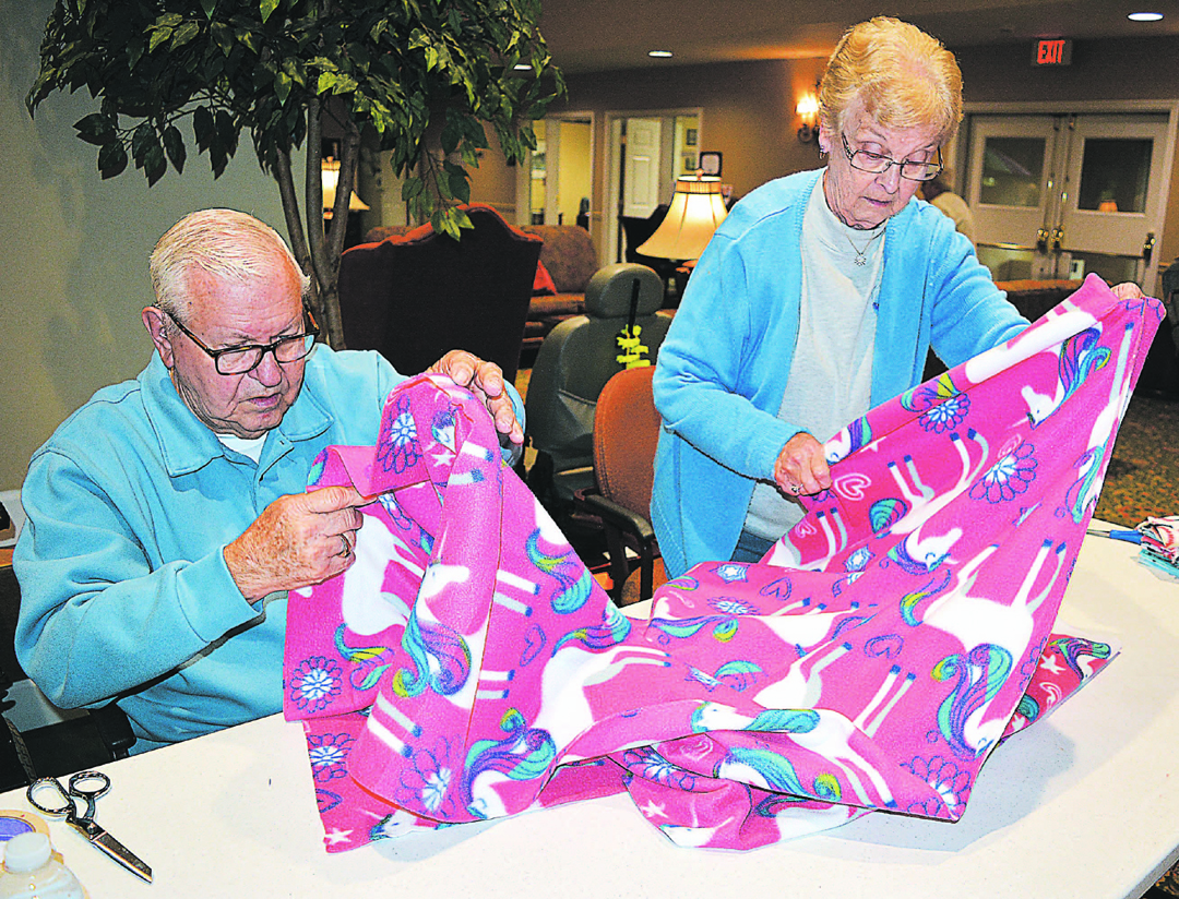 Independence Village residents Jerry and Jackie Bambousek work together on a unicorn-themed blanket for Project Linus. Photo by C.J. Carnacchio.