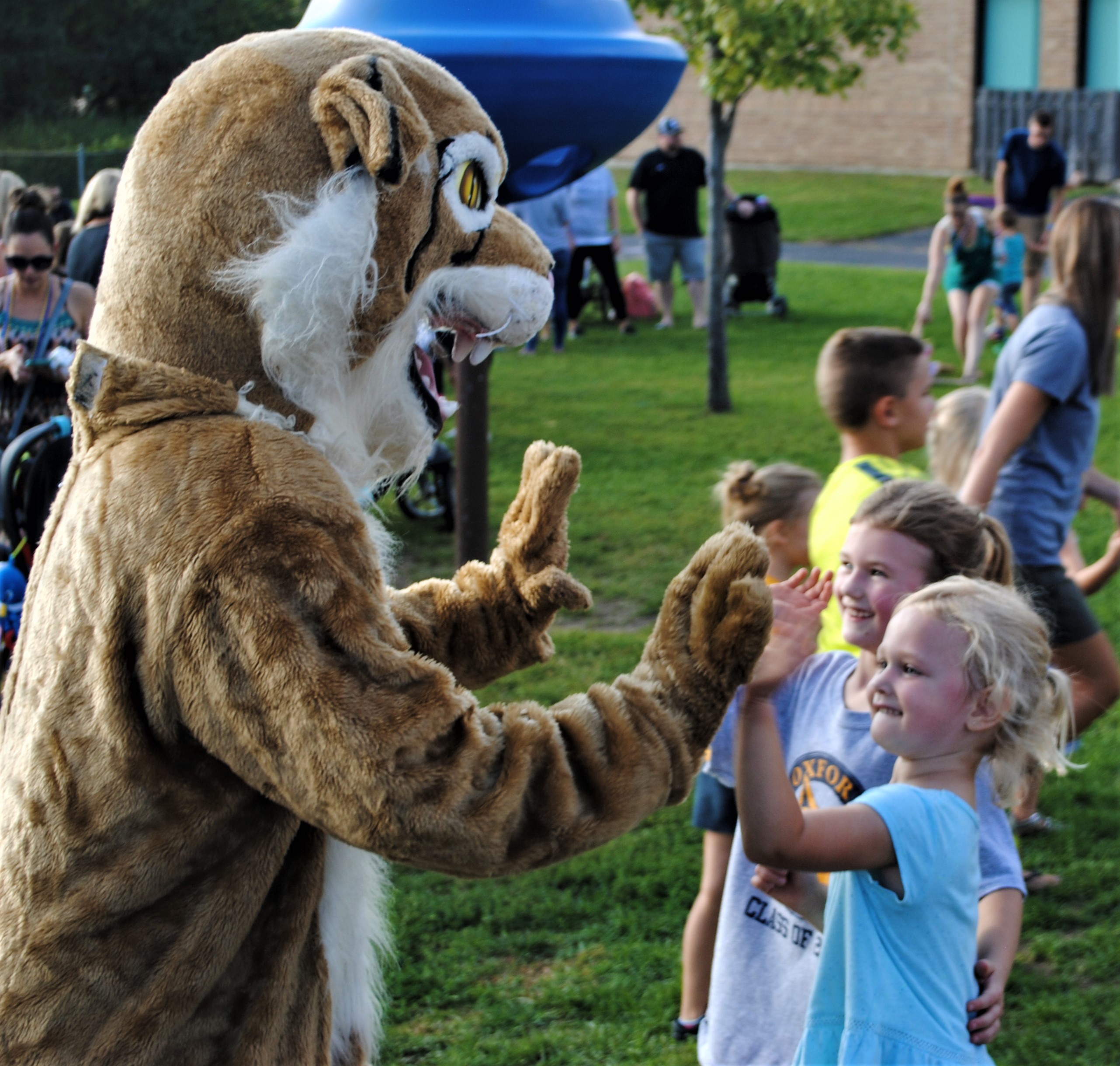 Daniel Axford kindergartener Brooklyn Harris and her 3-year-old sister Charlotte danced and high-fived the Wildcat before Friday’s big game. Photo by Shelby Tankersley.