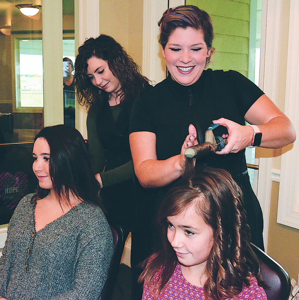 Amanda McFarland (foreground), owner of Valor Salon, located at 26 E. Burdick St. in downtown Oxford, styles the hair of young Parker Mysen. Behind them Valor Salon Manager Kaleigh Cameron works on the hair of her sister, McKenna Cameron. Photo by C.J. Carnacchio.