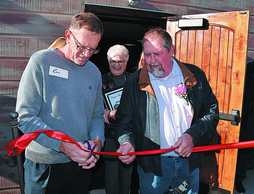 FISH Board Member Ron Wood (left) and donor Dan Davis cut the ceremonial ribbon for the new pantry on M-24. Photo by C.J. Carnacchio.