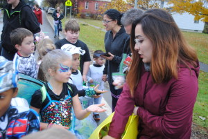 Dressed as a fairy, Adria Kurzawa gets a bag of candy from Noelia Vazquez. Photo by Shelby Tankersley