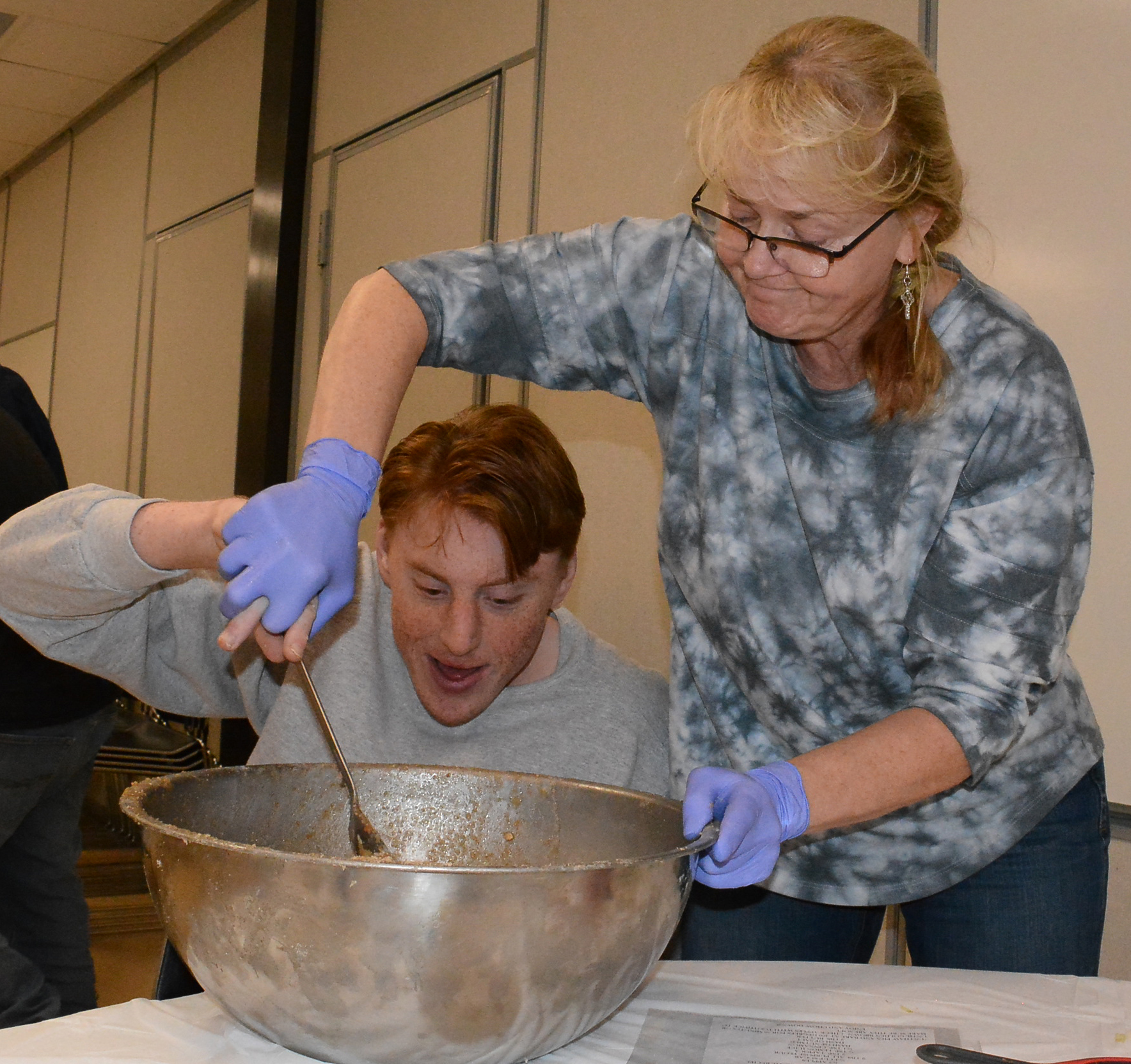 LOFT student Nathaniel Perry mixes up apple pie filling with some help from his mother, Andrea Perry. Photo by C.J. Carnacchio.