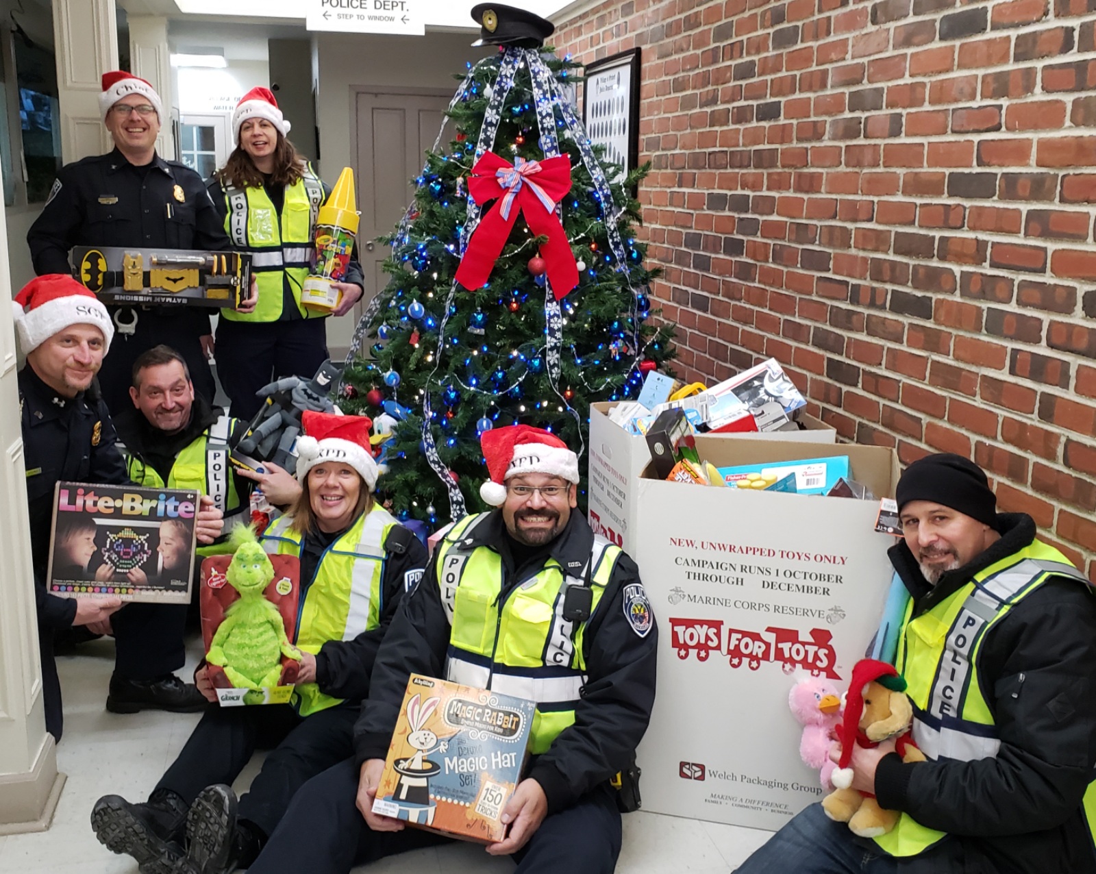 Oxford Village police officers show off some of the toys folks donated for kids in need. Photo provided.