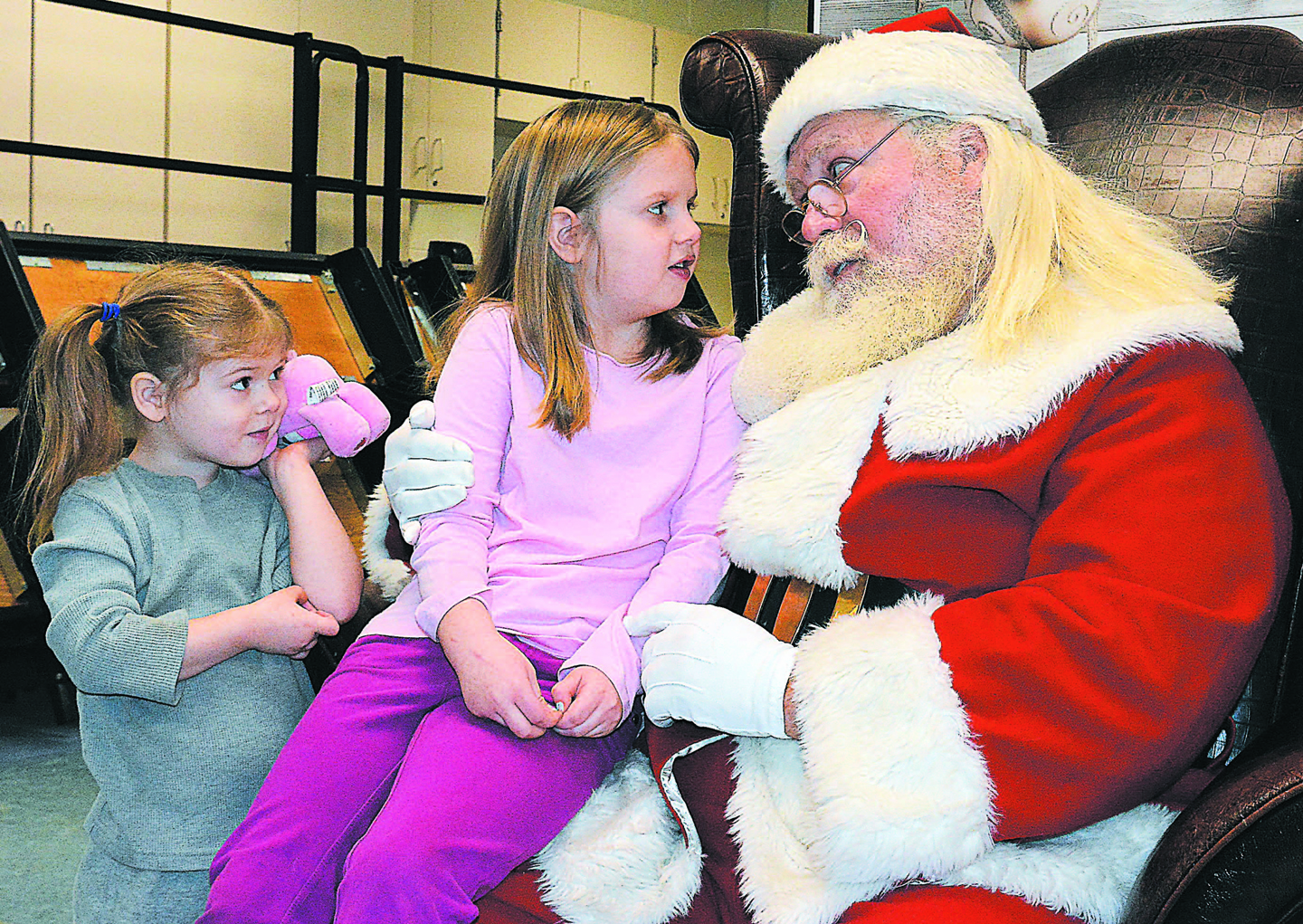Visiting with the one and only Santa Claus are sisters Lena Starzyk (left), 3, and Sophia, 6. Sophia is a first-grader at Lakeville Elementary School. Photo by C.J. Carnacchio.