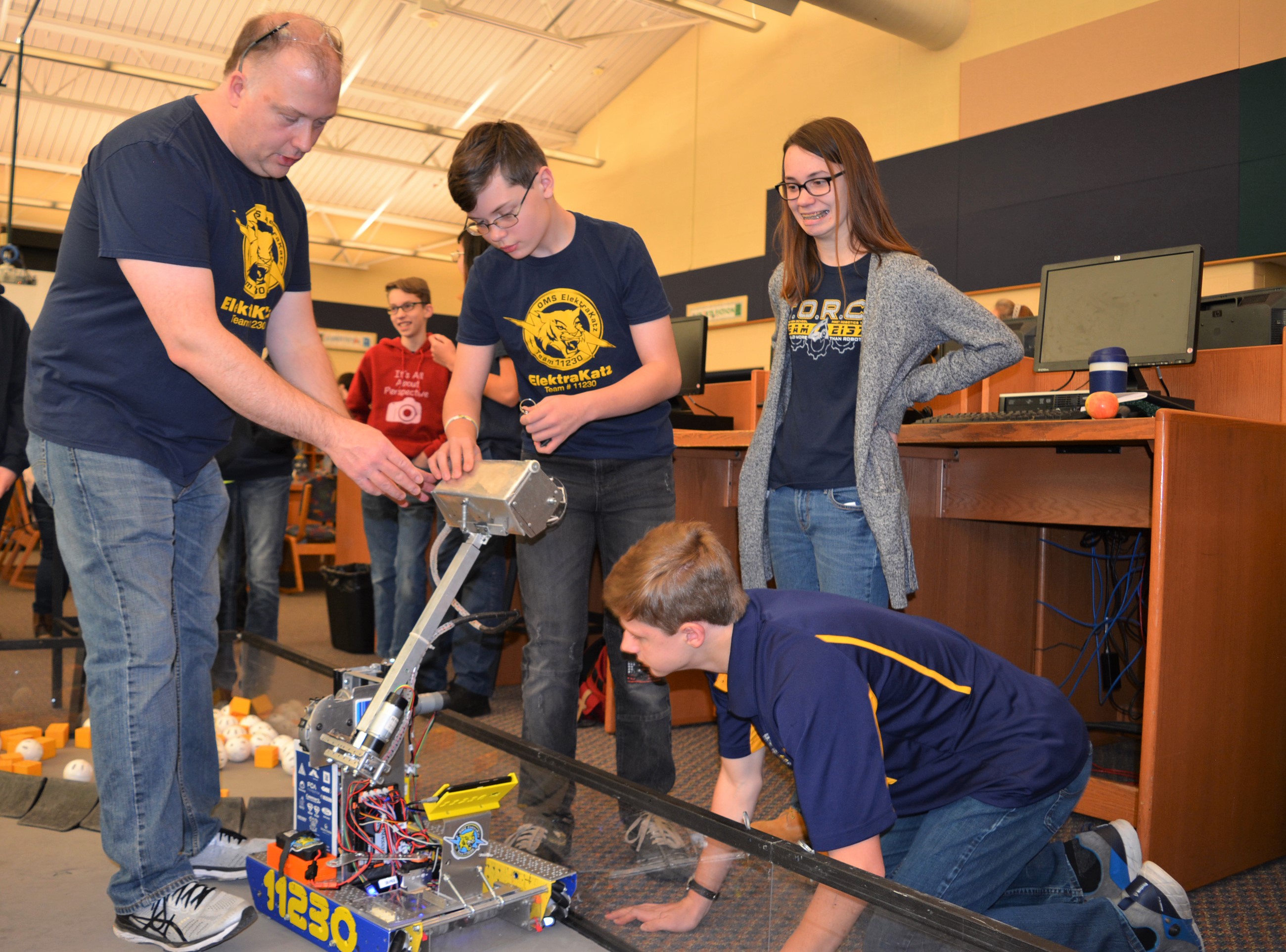 (From left) OMS robotics mentor Dennis Hurst and student Gavin Shafer make some adjustments with assistance from OHS robotics students Keira Houston and Jason Grabowski. Photo by C.J. Carnacchio.