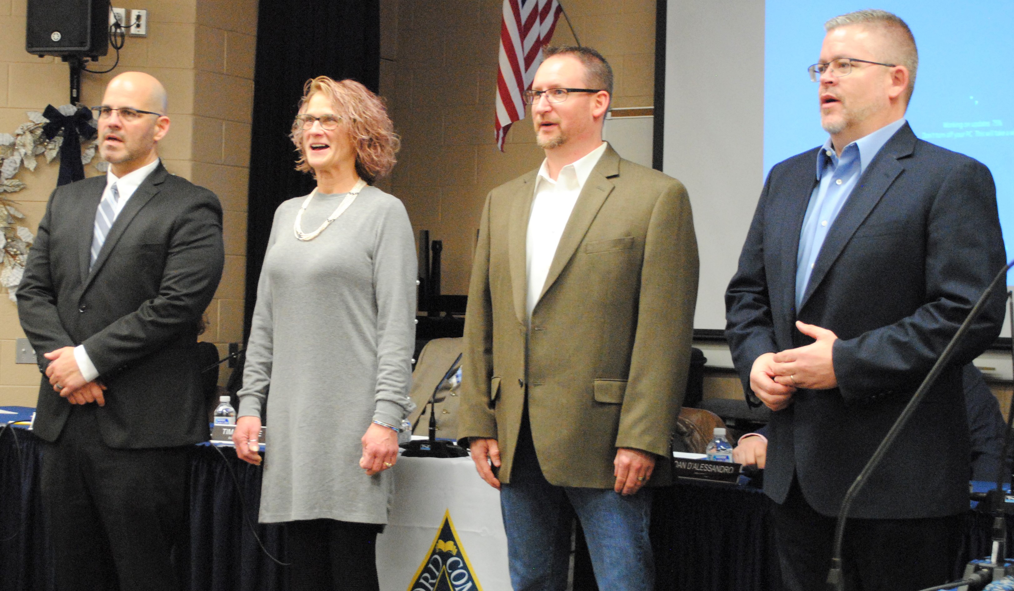 From left, incoming school board trustees Erick Foster, Mary Hanser and Chad Griffith along with Board Treasurer Korey Bailey, a returning trustee, take the oath of office. Photo by Shelby Tankersley.