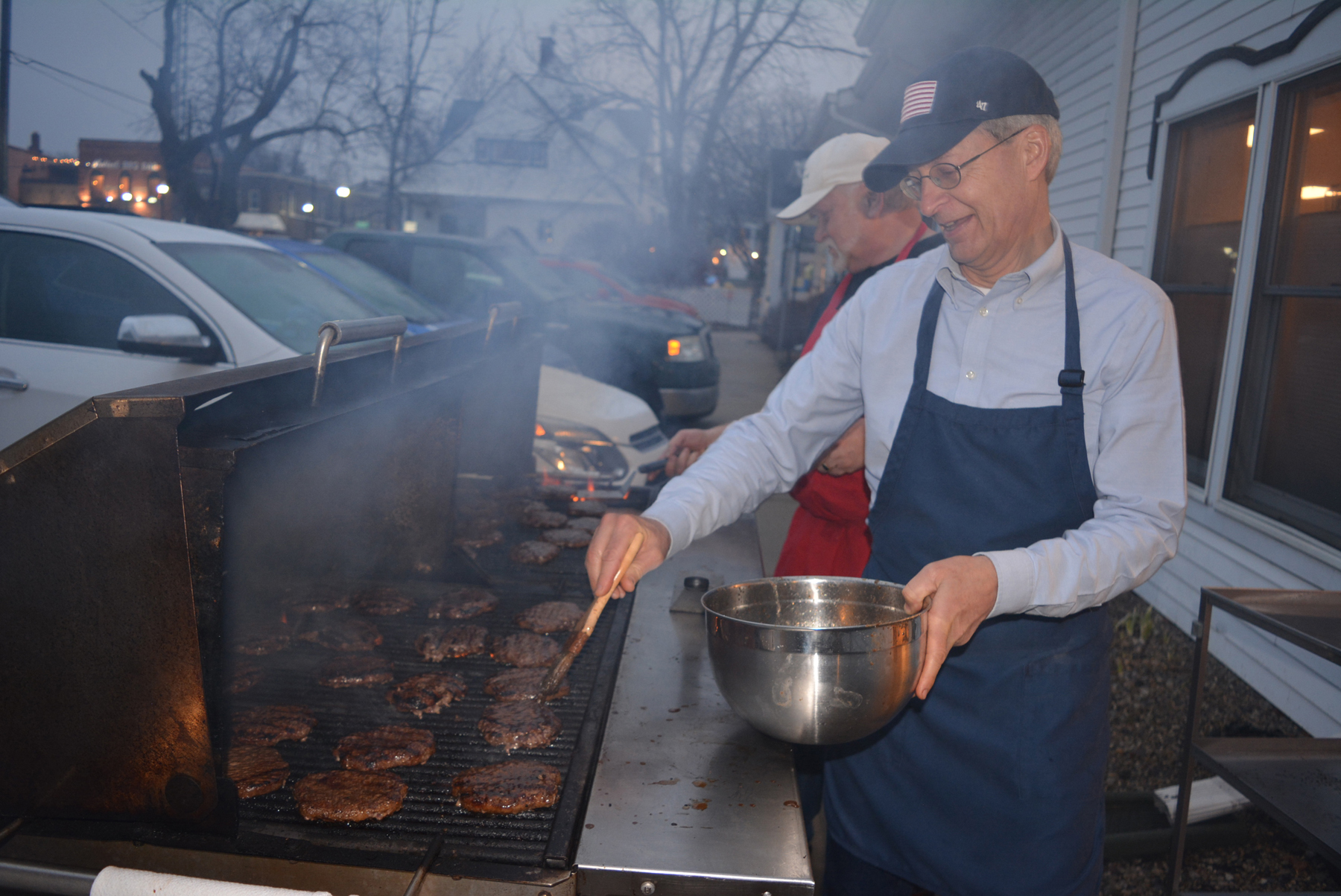 Grilling up hamburgers for hungry guests at Lake Orion United Methodist Church is Community Meals volunteer Clint Syverson, of Oakland Township. Photo by C.J. Carnacchio.