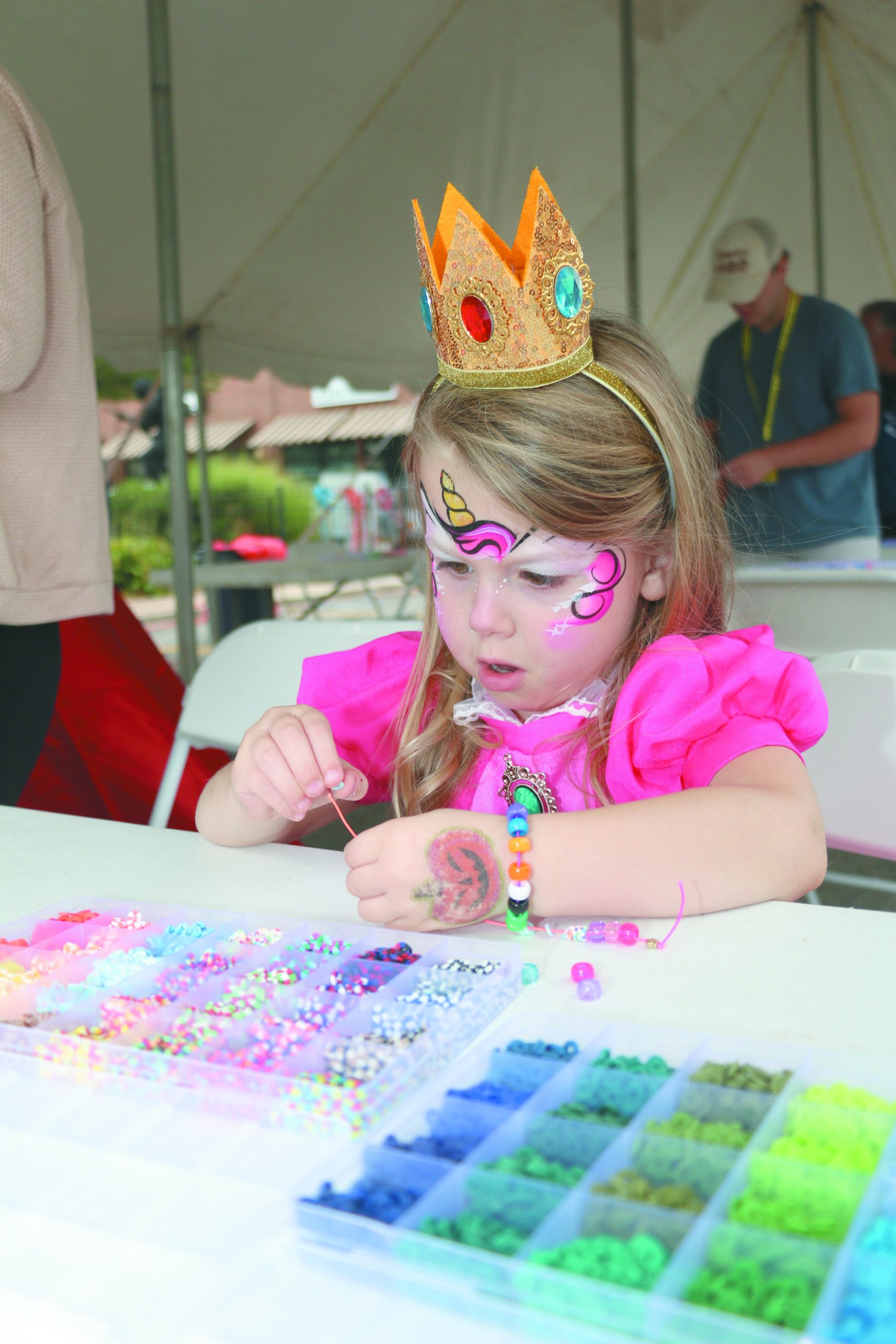 Claire dressed as Princess Peach making bracelets