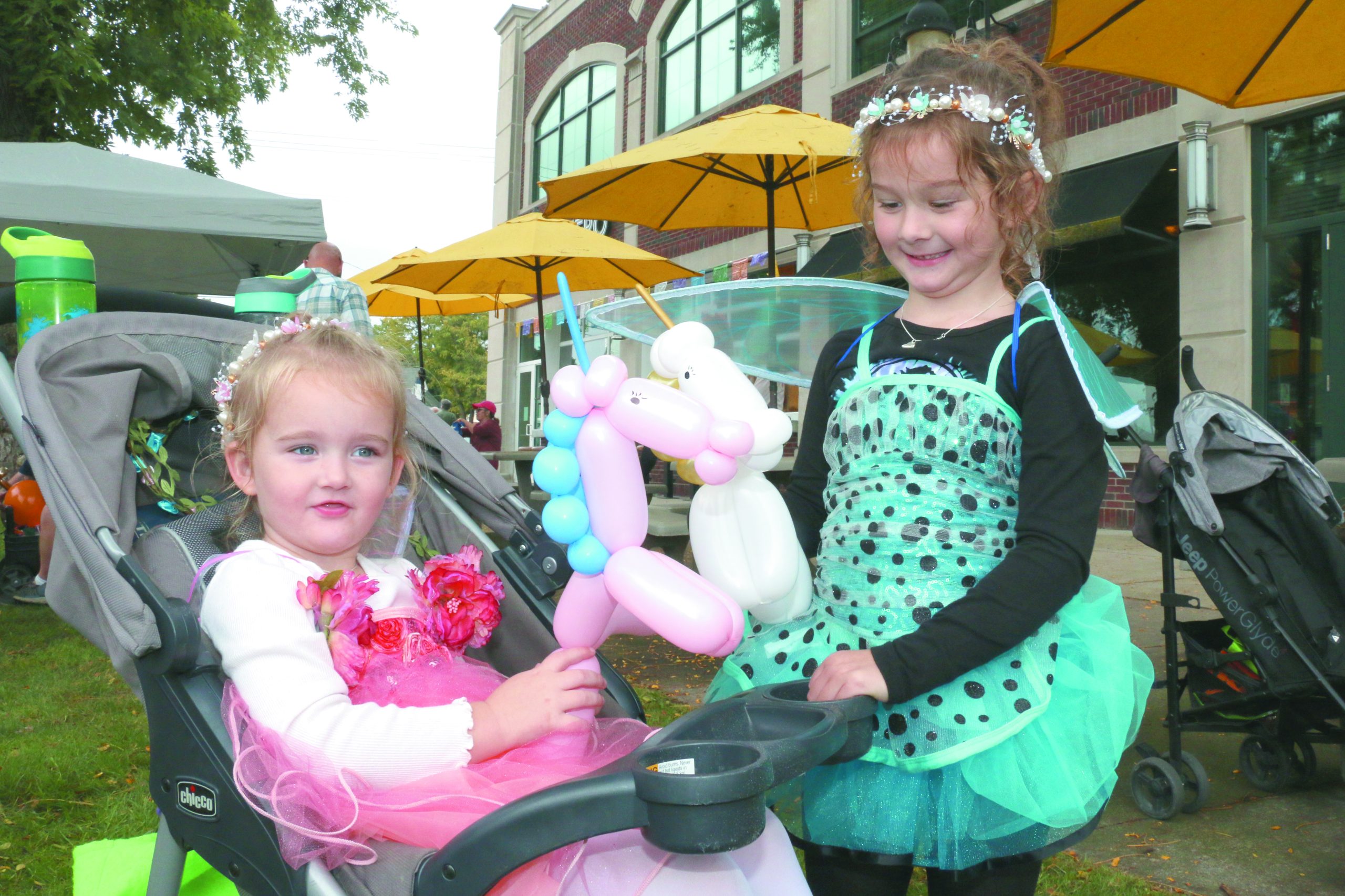 Sisters Mira and Romi playing with their balloon unicorns